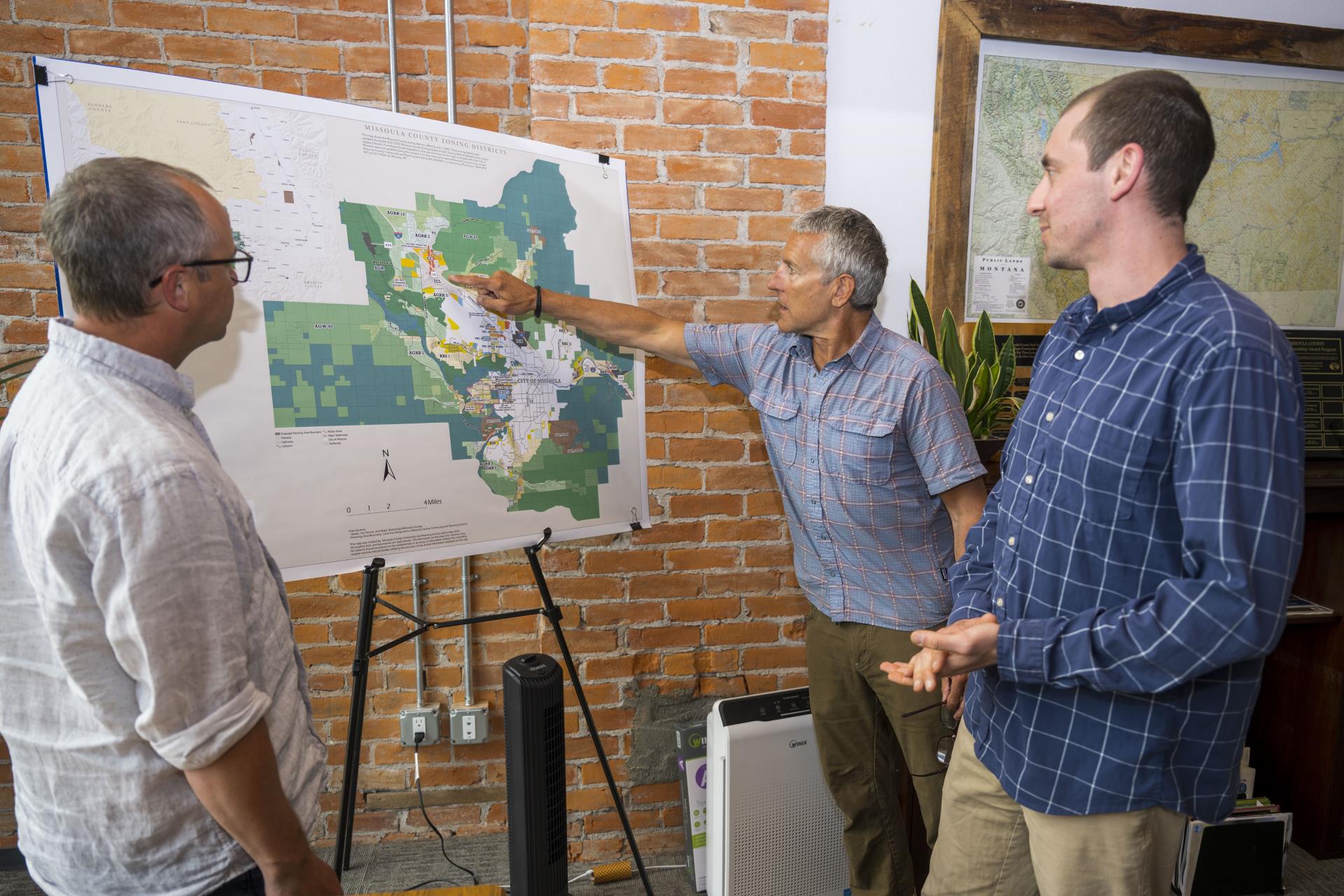 County staff standing and looking at the zoning map.