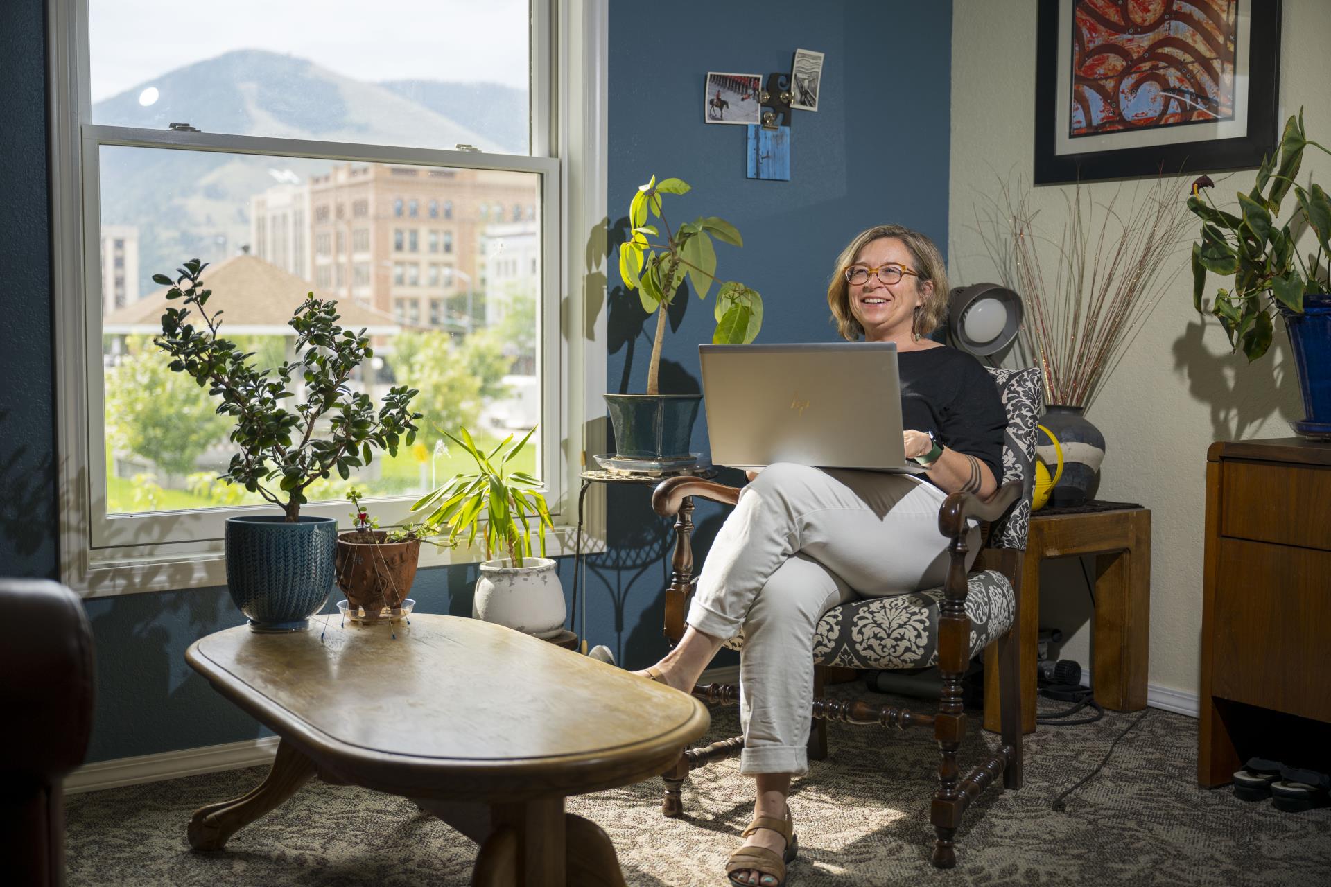 An interior view of an office in the Community Justice Department building, a woman is seated with a laptop.