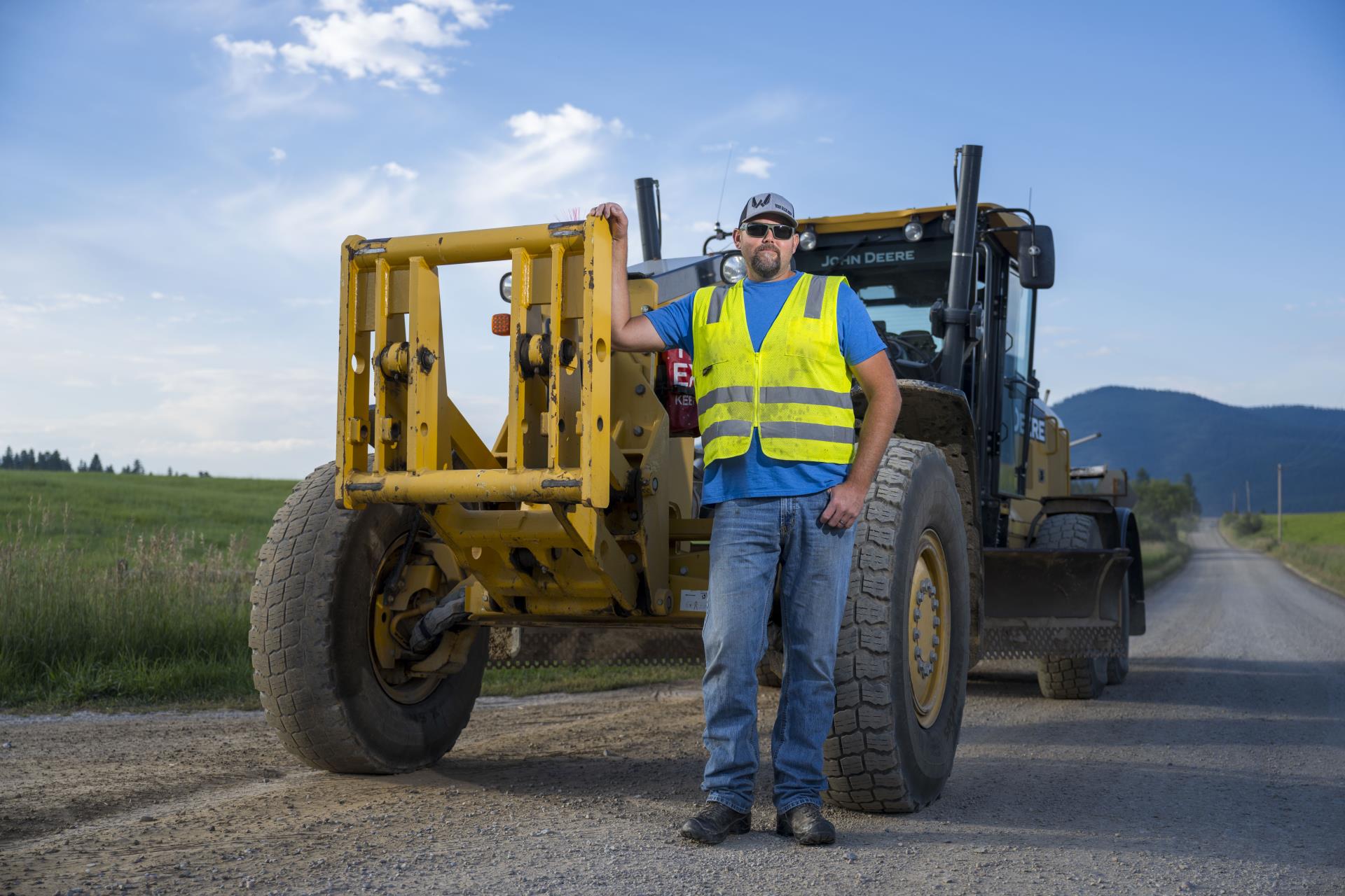 Public Works staff in a high-vis vest standing in front of machinery